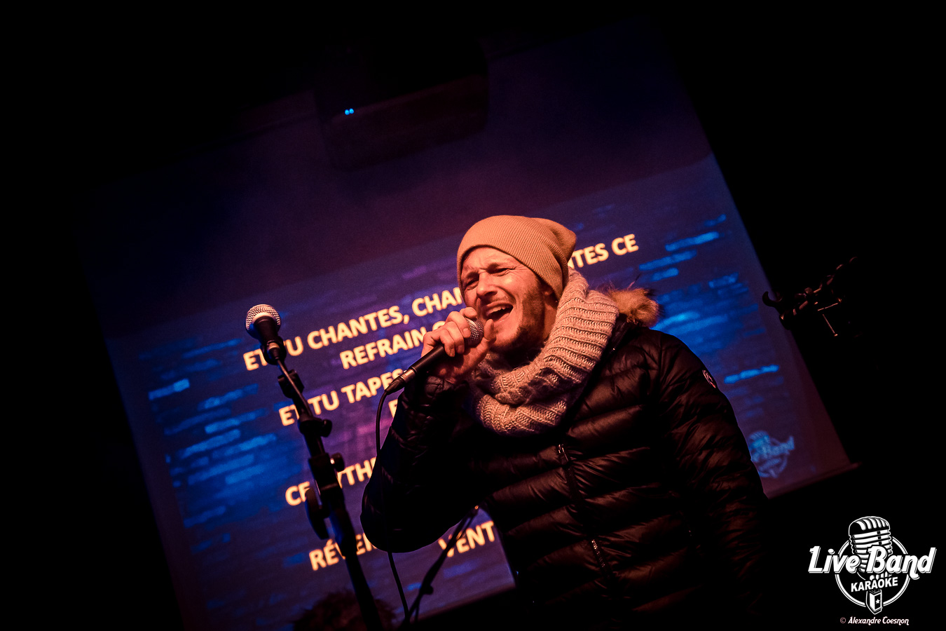 Chanteur invité devant les paroles projetées en grand écran